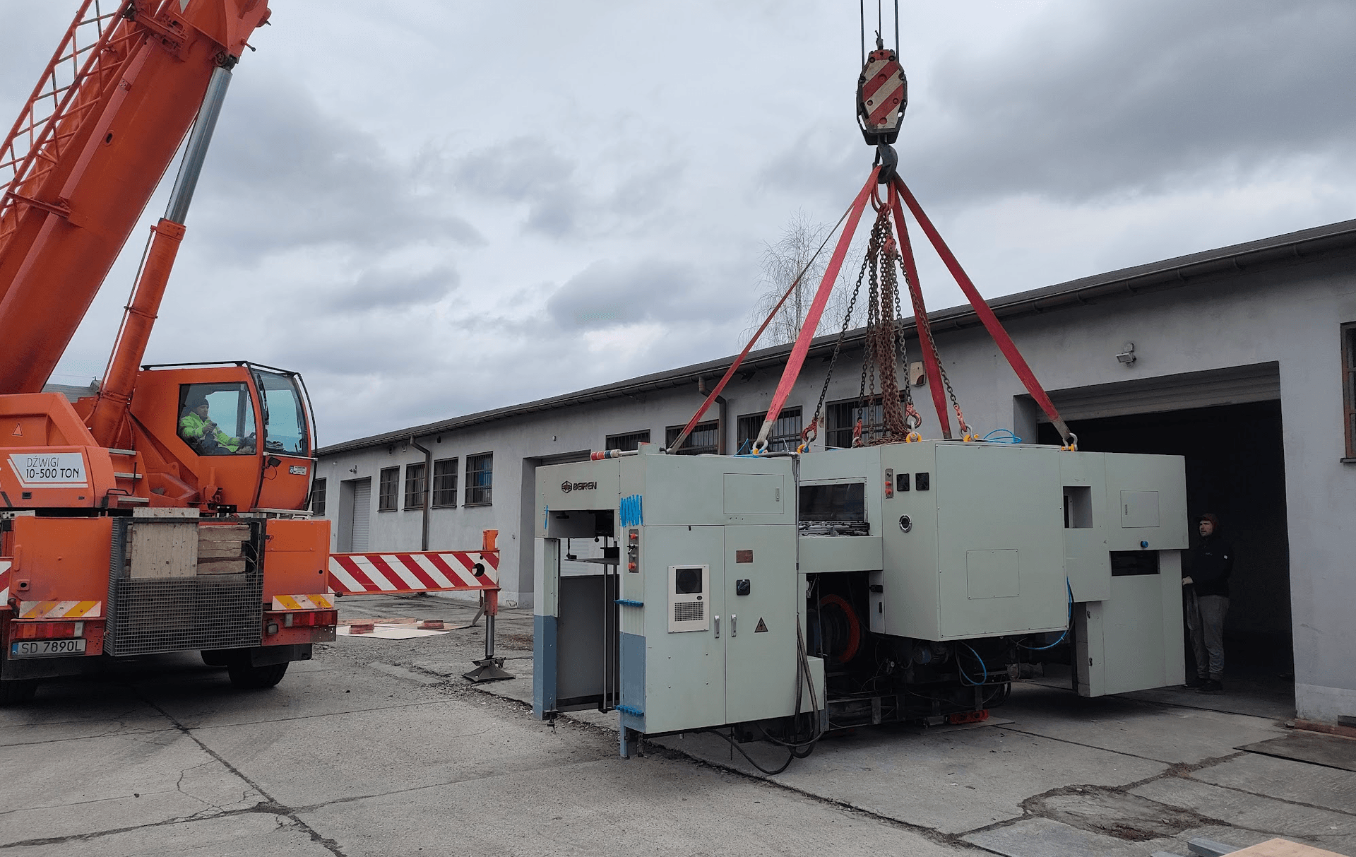Dźwig żuraw przy relokacji ciężkiej maszyny przemysłowej